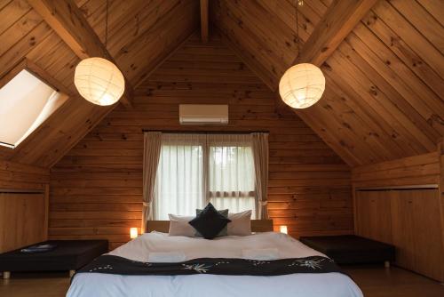 a bedroom with a bed in a wooden attic at Balls Deep Inn Villas in Hakuba