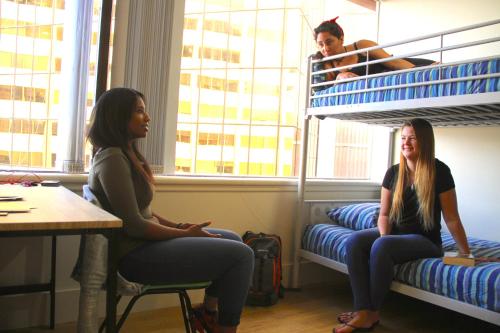 two women sitting on bunk beds in a room at Choice Backpackers in Auckland