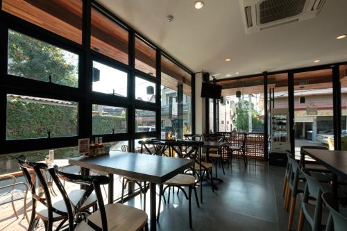 a restaurant with tables and chairs and windows at Wealth Boutique Hotel Chiang Mai in Chiang Mai