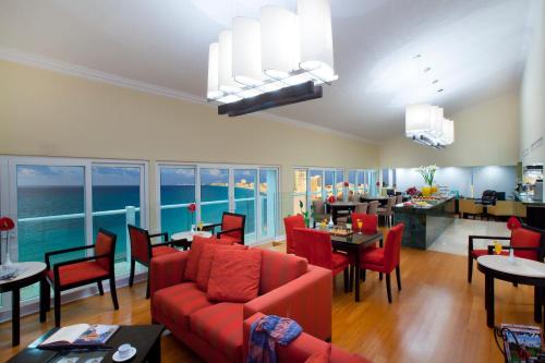 a living room with a red couch and a dining room at Krystal Cancun in Cancún