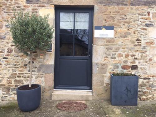 a front door of a stone building with a potted plant at Maison d'hôtes les Escures in Acigné