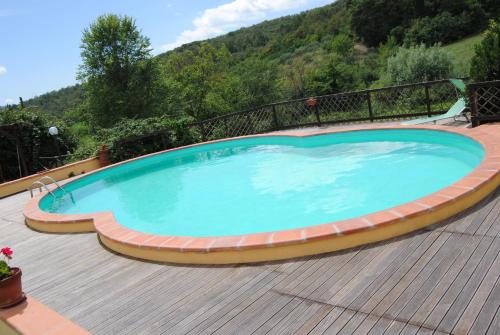a large swimming pool on a wooden deck at La Chiusuraccia in Barberino di Mugello