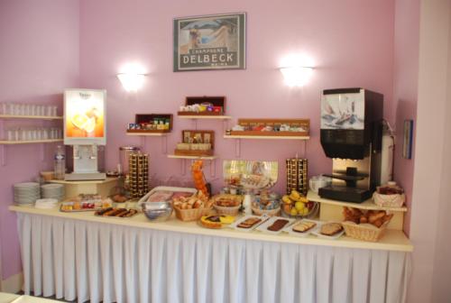 a bakery with a counter with food on it at The Originals City, Hôtel Cathédrale, Lisieux (Inter-Hotel) in Lisieux