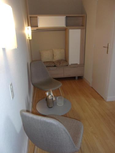 a chair sitting in a room with a bed at Chambres d'hôtes Le Gilliard in Chavanges
