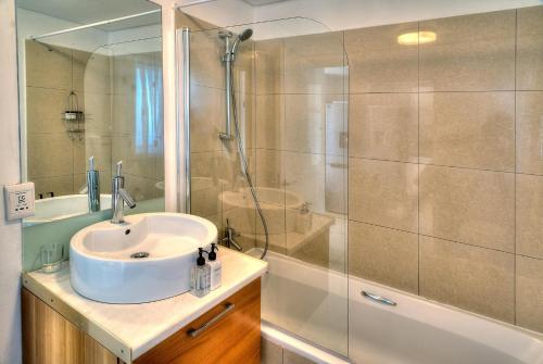 ein Bad mit einem Waschbecken und einer Dusche in der Unterkunft Horizon Bay 1404 in Bloubergstrand