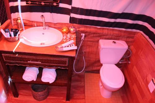 a bathroom with a pink toilet and a sink at Legend Desert camp in Fulayj al Mashāʼikh