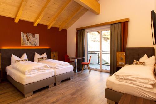 een slaapkamer met twee bedden en een balkon bij Lux Appartements in Ischgl