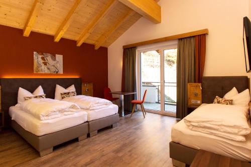 sypialnia z 2 łóżkami i balkonem w obiekcie Lux Appartements w mieście Ischgl