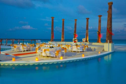 a restaurant on the water with tables and chairs at Krystal Cancun in Cancún