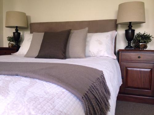 a bedroom with a large bed with two lamps at Jacaranda House Garden Suite in Brisbane