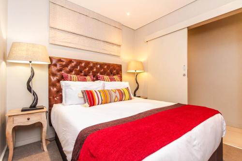 a bedroom with a large bed with a red blanket at Zimbali Suite 521 in Ballito