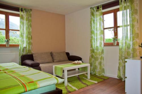 a bedroom with a bed and a couch and windows at Ferienwohnung Eylmann in Bad Reichenhall