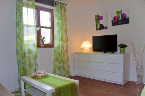a living room with a tv on a dresser and a table at Ferienwohnung Eylmann in Bad Reichenhall