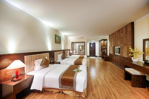 a hotel room with two beds and a television at Muong Thanh Grand Cua Lo Hotel in Cửa Lò