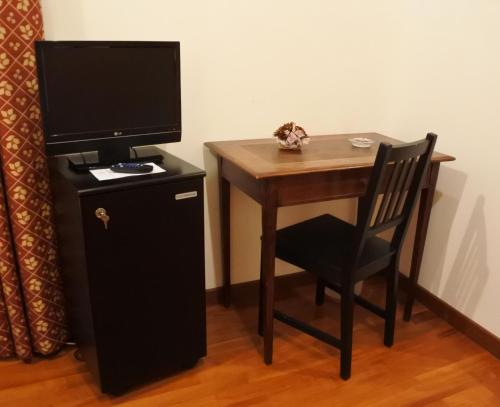 escritorio pequeño con TV y silla en Gorizia Inn, en Gorizia