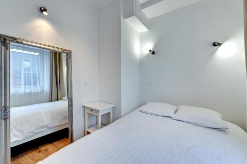 グダニスクにあるTriApart Chmielna Park 1 Gdanskのベッドルーム(白いベッド1台、鏡付)