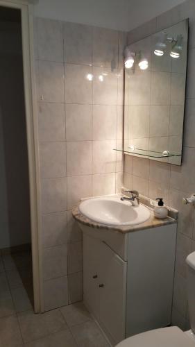 a bathroom with a sink and a mirror at Appartement Le Cernuschi 2C in Menton