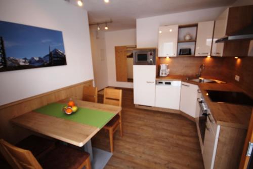 a small kitchen with a wooden table and a table and chairs at Haus Dorfblick in Gerlos