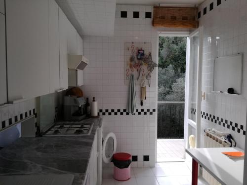 una cucina con pareti piastrellate in bianco e nero di Olivo apartment with sea view a Portovenere