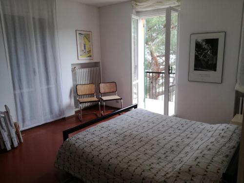 - une chambre avec un lit, une chaise et une fenêtre dans l'établissement Olivo apartment with sea view, à Portovenere