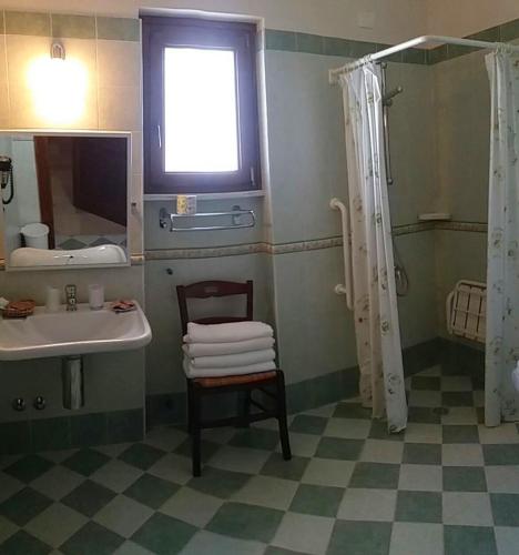 a bathroom with a sink and a shower and a chair at Masseria De Michele in Montalbano