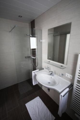 a bathroom with a sink and a shower and a mirror at Haus Dorfblick in Gerlos