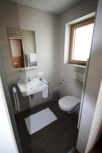 a bathroom with a sink and a toilet and a mirror at Haus Dorfblick in Gerlos