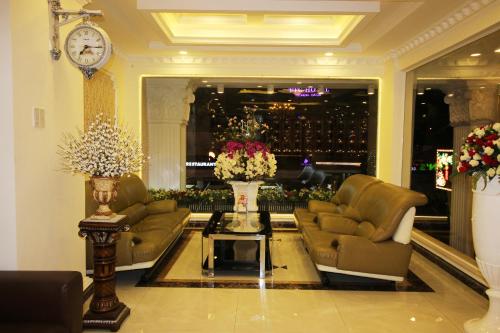 a living room with couches and a table with flowers at Royal Dalat Hotel in Da Lat