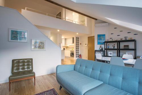 a living room with a blue couch and a table at Downtown Boutique Duplex in Lisbon