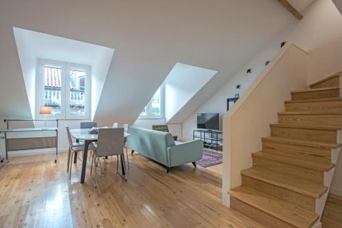 a living room with a staircase and a table and chairs at Downtown Boutique Duplex in Lisbon