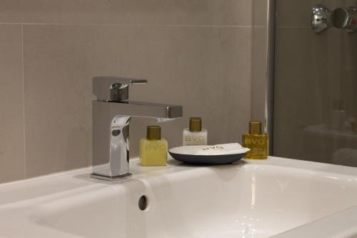 a bathroom sink with a faucet and some soap at Noviciado Apartment in Madrid