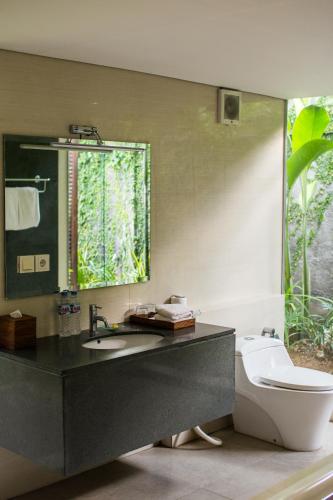 a bathroom with a sink and a toilet at The Astari Villa and Residence in Jimbaran