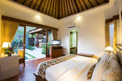 a bedroom with a large bed and a tv in it at The Astari Villa and Residence in Jimbaran