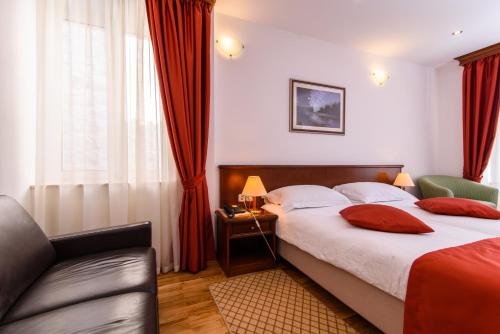 a hotel room with a bed and a couch at Heritage Hotel Vila Sikaa in Trogir