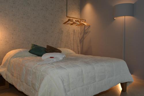 a bedroom with a bed with white sheets and a lamp at Un B&B al Belvedere in Enna