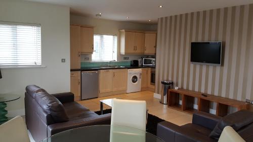 een woonkamer met 2 banken en een keuken bij St Bridget's Apartments in Galway
