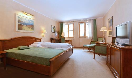 a hotel room with a bed and a television at Altstadthotel Bräuwirt in Weiden