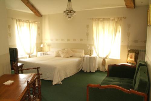 a bedroom with a white bed and two windows at Les Chambres d'hôtes Benoit Breton in Bulgnéville