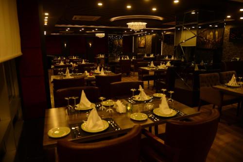 a restaurant with tables and chairs with napkins on them at Ankawa Royal Hotel & Spa in Erbil