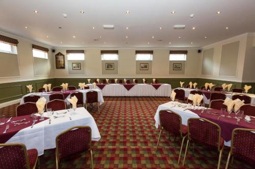 um salão de banquetes com mesas e cadeiras numa sala em The Golf Hotel em Silloth