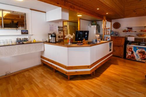 a kitchen with a wooden floor and wooden cabinets at BaseCamp NorthCape in Skarsvåg