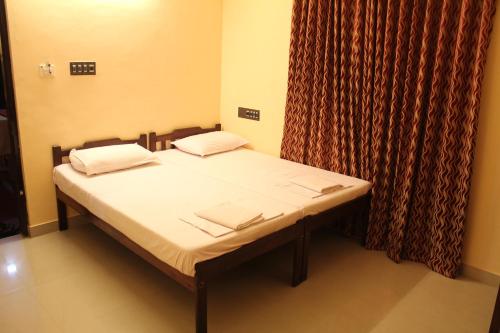 a small bedroom with a bed and a curtain at Bastian Homestay in Cochin