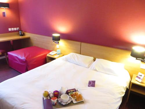 ein Hotelzimmer mit einem Bett, auf dem ein Tablett mit Essen steht in der Unterkunft Mercure Hexagone Luxeuil in Luxeuil-les-Bains