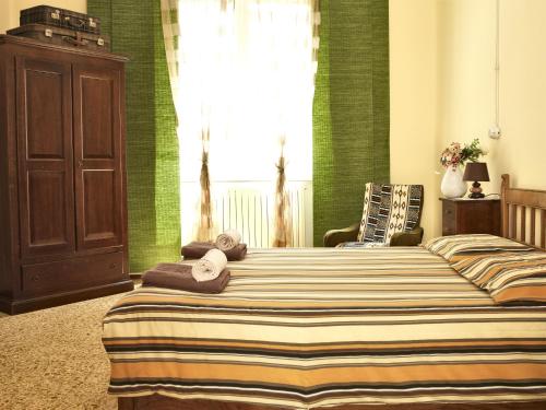 a bedroom with two beds with green walls and a window at Domo Silvia E Paolo in Nuoro
