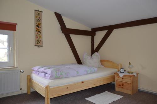 a bedroom with a wooden bed with purple sheets at Ferienwohnung Siebmann in Neuruppin