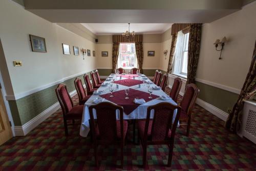 a dining room table with chairs and a table cloth at The Golf Hotel in Silloth