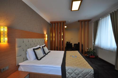 a bedroom with a large bed with white sheets and pillows at Double Comfort Hotel in Ankara