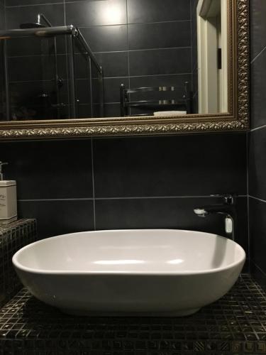 a white bath tub in a bathroom with a mirror at Apartments Lux in city center Lviv in Lviv