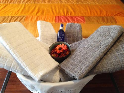 a table with towels and a bowl of flowers on it at Chambre D'Hôtes le Phenix in Saint-Martin-du-Vivier