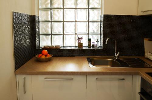 a kitchen with a sink and a bowl of fruit on a counter at Apartments Miočić in Zadar